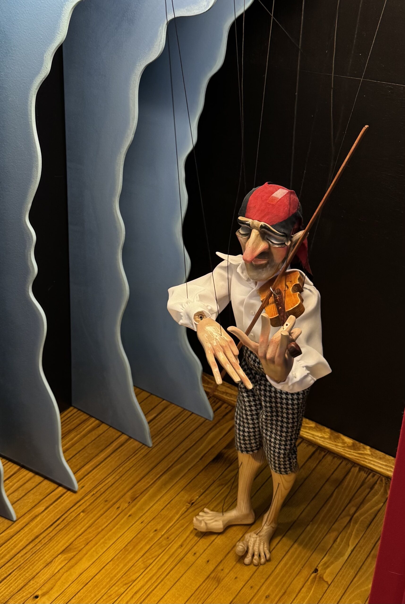 A marionette puppet suspended from its control strings.